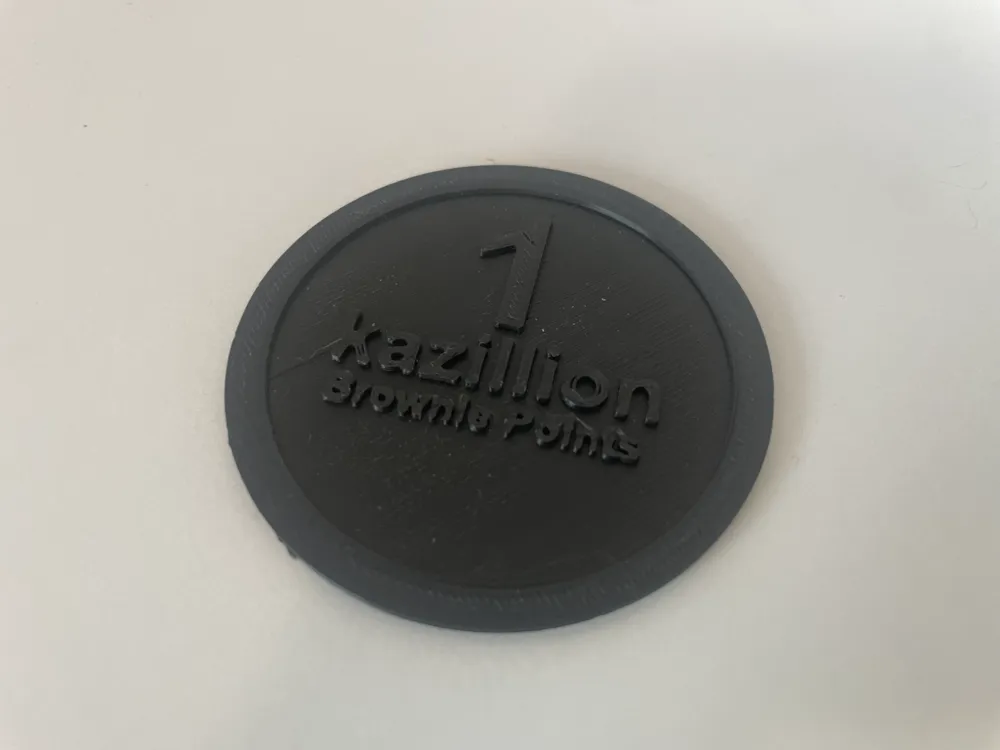 A black coin that says 1 kazillion brownie points on it